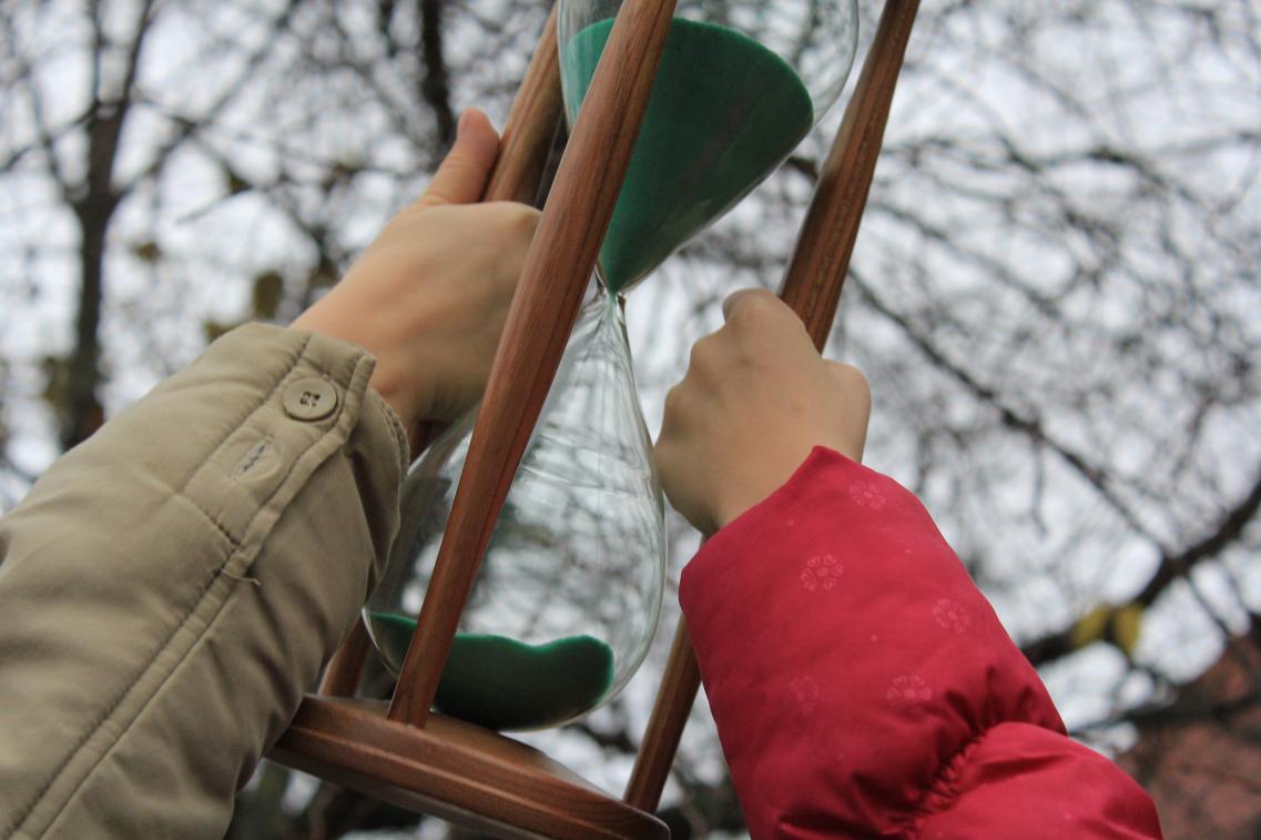 Kinderhände halten Sanduhr
