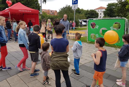 Roberto Kobelt spielt mit Kindern Torwandschießen