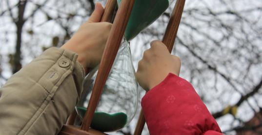 Kinderhände halten Sanduhr