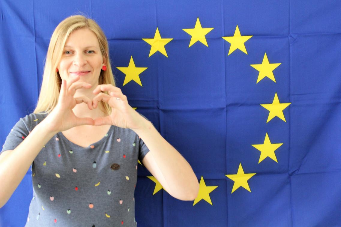 Madeleine Henfling zeigt Herz mit Händen vor Europaflagge