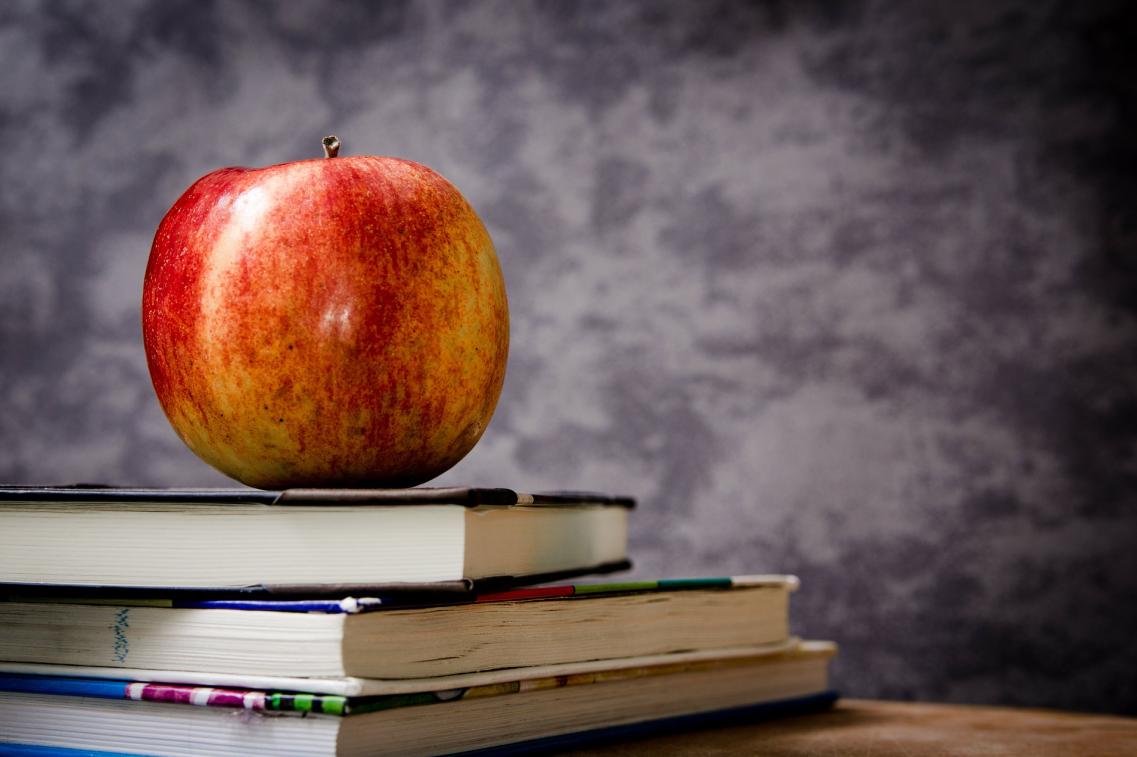 Ein Apfel liegt auf Schulbüchern Ein Apfel liegt auf Schulbüchern