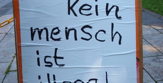 Plakat mit der Aufschrift "Kein Mensch ist illegal"