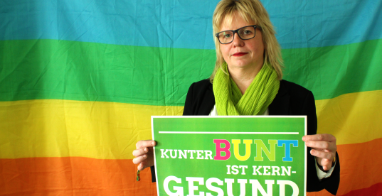 Babett Pfefferlein vor Regenbogenflagge