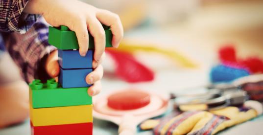 Kind spielt mit bunten Bauklötzen Kind spielt mit bunten Bauklötzen