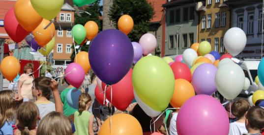 Kinder halten bunte Luftballons in den Händen 