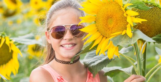 Mädchen in Sonnenblumenfeld